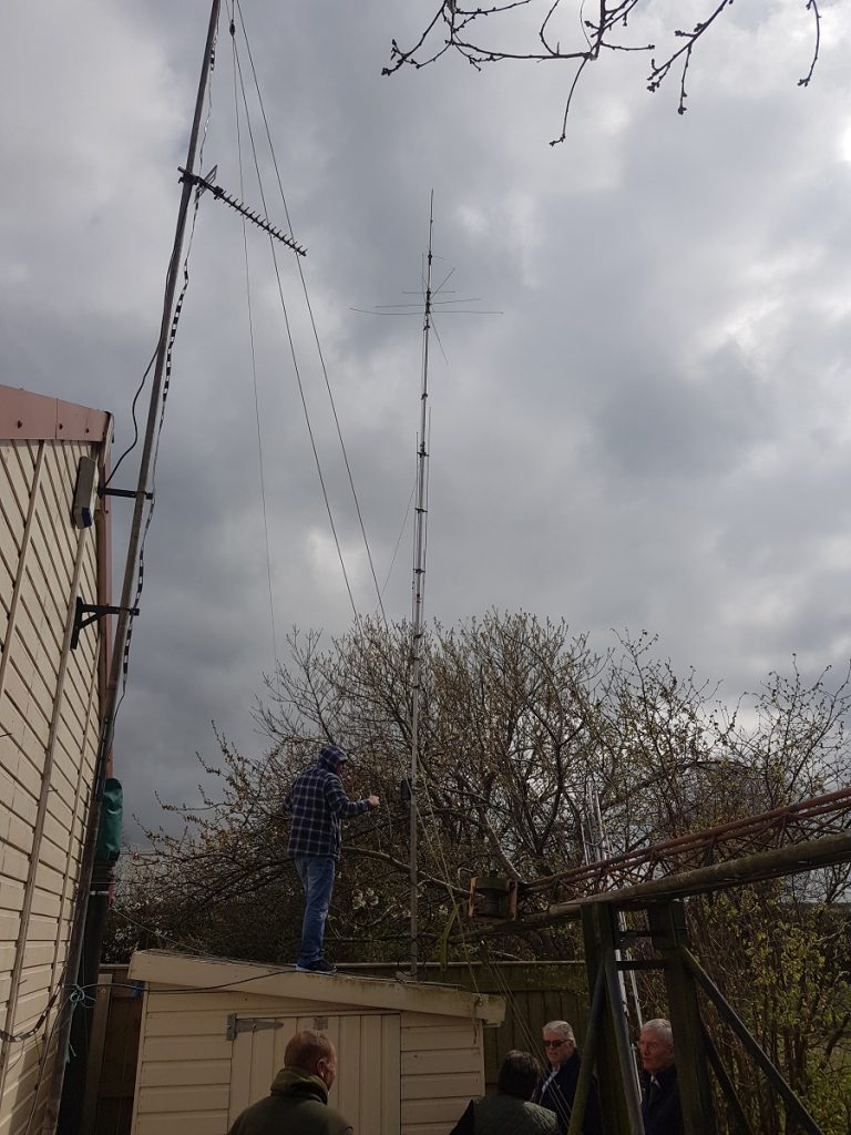 Members installing the AV-640 on the side of the Shed